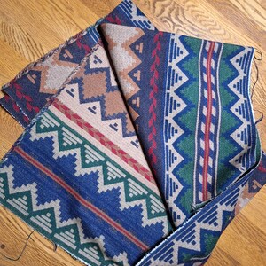Peut inclure: Morceaux de tissu pli&eacute;s avec des motifs d'inspiration sud-ouest. Les motifs pr&eacute;sentent des formes g&eacute;om&eacute;triques dans les tons de bleu, beige, vert et rouge. Le tissu semble &ecirc;tre de poids moyen, adapt&eacute; &agrave; la tapisserie ou aux projets de couture.