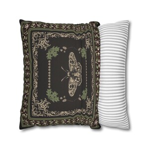 May include: A black and green decorative pillow with a butterfly design and a white and gray striped pillow.