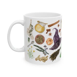 May include: White ceramic mug with a colorful illustration of various witchy items, including a witch's hat, herbs, mushrooms, a pumpkin, and a jar of honey.