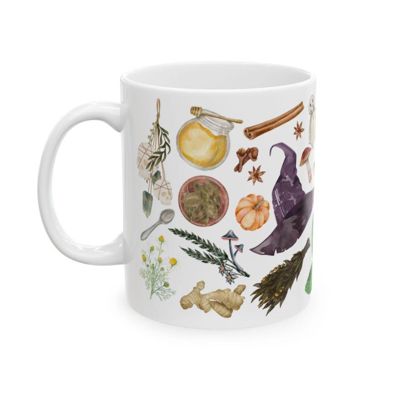 May include: White ceramic mug with a colorful illustration of various witchy items, including a witch's hat, herbs, mushrooms, a pumpkin, and a jar of honey.