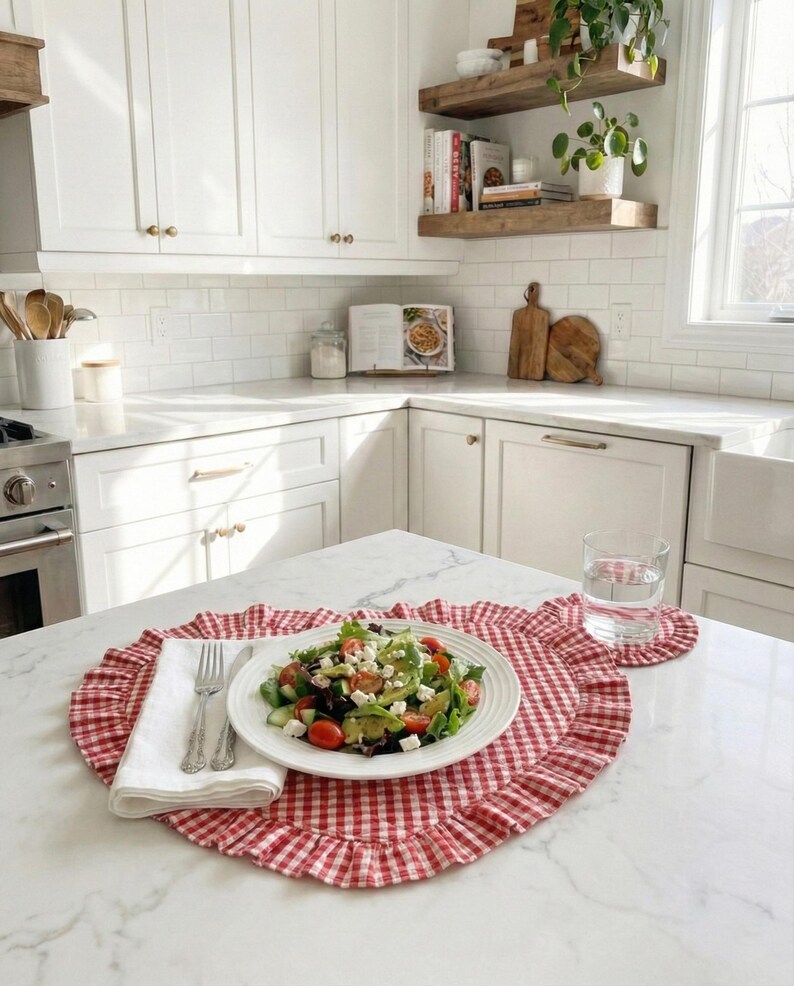 Puede incluir: Una ensalada fresca en un plato blanco, colocada sobre un mantel individual de cuadros rojos y blancos con borde con volantes. Un posavasos a juego y un vaso de agua est&aacute;n cerca. Una servilleta blanca y cubiertos completan el conjunto.