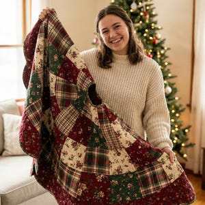 May include: A circular Christmas tree skirt featuring a patchwork design of quilted fabric squares. The pattern alternates between dark red floral prints, green floral prints, and a multi-colored plaid fabric in red, green, and cream tones.