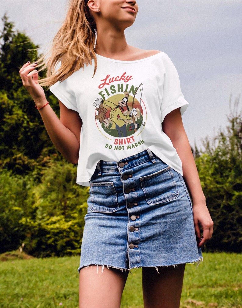 May include: White t-shirt with a cartoon image of Goofy fishing. The text on the shirt reads "Lucky Fishin' Shirt Do Not Wash".