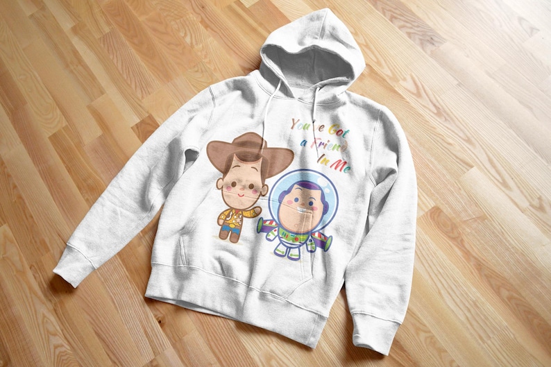 May include: White hoodie with a cartoon image of Woody and Buzz Lightyear from Toy Story. The text "You've got a friend in me" is printed in rainbow colors on the hoodie.