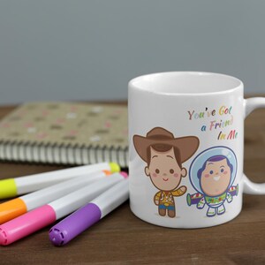 May include: White ceramic mug with a colorful cartoon image of Woody and Buzz Lightyear from Toy Story. The mug has the text "You've Got a Friend in Me" printed on it.
