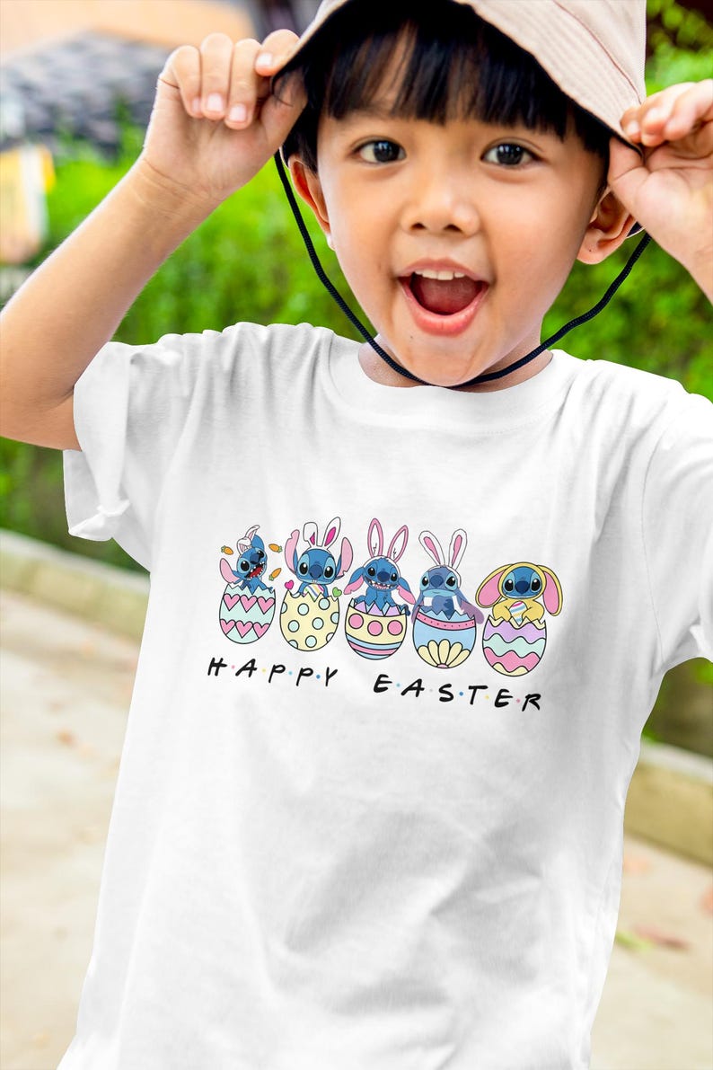 May include: A white t-shirt with a graphic of five blue Stitch characters wearing bunny ears and sitting in Easter eggs. The text "HAPPY EASTER" is printed below the characters.