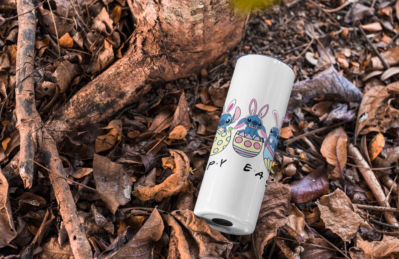May include: White tumbler with a blue cartoon character holding an Easter egg. The text "Happy Easter" is printed on the tumbler.