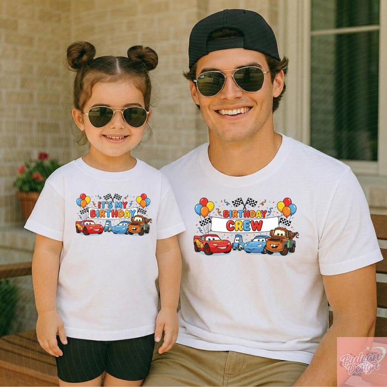May include: White t-shirts with colorful cartoon car graphics. One shirt reads "IT'S MY BIRTHDAY" and the other says "BIRTHDAY CREW". Both shirts feature race flags, balloons, and confetti.