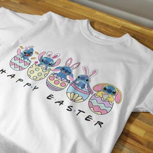 May include: White t-shirt with a graphic of Stitch characters from Lilo & Stitch in Easter egg baskets. The text "Happy Easter" is printed below the characters.