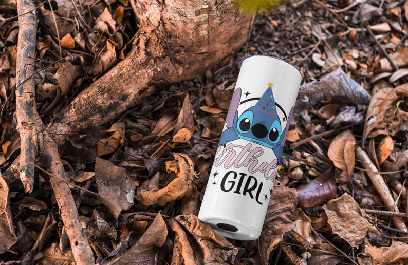 Op de afbeelding: Een witte tumbler met een blauw cartoonfiguur dat een feestmuts draagt. De tekst "Birthday Girl" staat in roze op de tumbler.