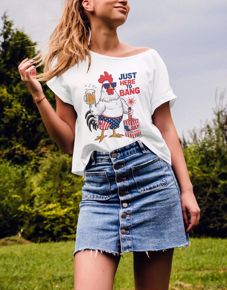 May include: White t-shirt with a cartoon rooster wearing sunglasses and holding a beer. The rooster is wearing red, white, and blue shorts and holding a firework. The text on the shirt says "Just Here To Bang".