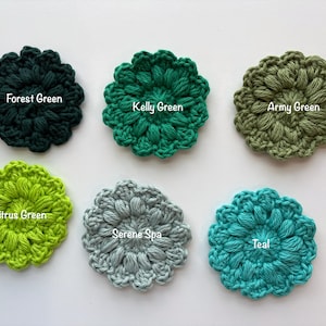 May include: Six circular crochet flower appliques arranged in two rows. The colors are labeled as Forest Green, Kelly Green, Army Green, Citrus Green, Serene Spa, and Teal. Each piece features a textured, puff-stitch design with scalloped edges.