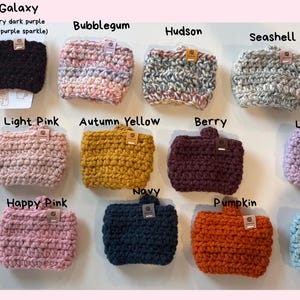 May include: A collection of fifteen rectangular crochet cup sleeves in various colours including Grey Speckle, Galaxy, Bubblegum, Hudson, Seashell, Multi, White Confetti, Light Pink, Autumn Yellow, Berry, Light Purple, Cream, Happy Pink, Navy, Pumpkin, and Soft Blue.