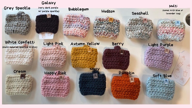 May include: A collection of fifteen rectangular crochet cup sleeves in various colours including Grey Speckle, Galaxy, Bubblegum, Hudson, Seashell, Multi, White Confetti, Light Pink, Autumn Yellow, Berry, Light Purple, Cream, Happy Pink, Navy, Pumpkin, and Soft Blue.