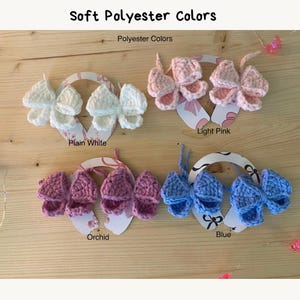 May include: Crocheted butterfly hair clips in plain white, light pink, orchid, and blue. The image shows the text "Soft Polyester Colors" and "Polyester Colors". Each butterfly is attached to a decorative card.