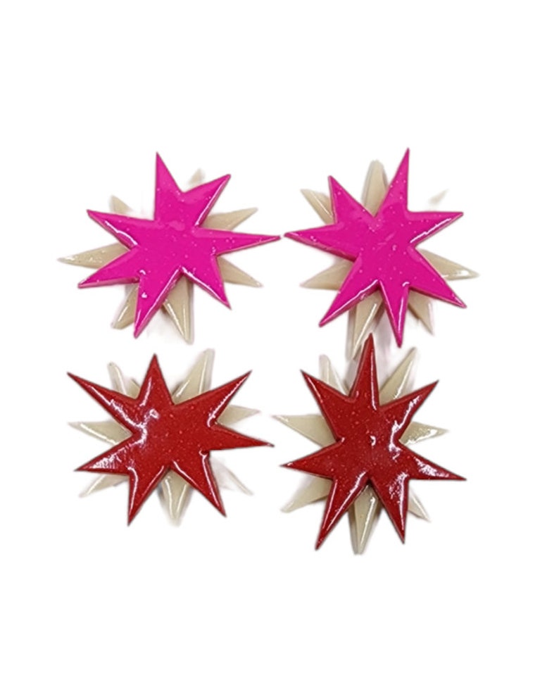 Pu&ograve; includere: Un paio di orecchini con due stelle rosa e due stelle rosse. Ogni stella ha un design a strati con una stella pi&ugrave; piccola sopra una stella pi&ugrave; grande.