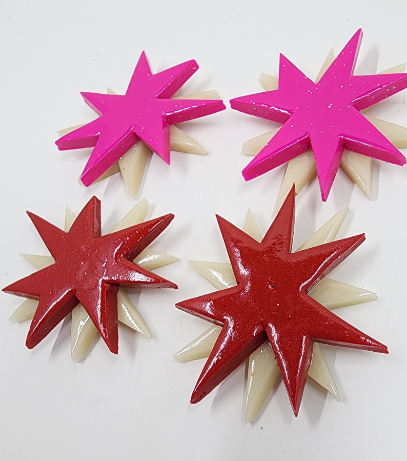 Pu&ograve; includere: Quattro ornamenti decorativi a forma di stella. Due sono rosa con accenti bianchi e due sono rossi con accenti bianchi.