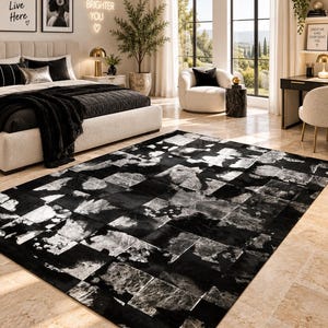Puede incluir: Una alfombra rectangular con un diseño de patchwork de cuadrados negros sólidos alternados con cuadrados texturizados en plata metálica. La alfombra está colocada sobre un suelo de baldosas claras, mostrando un patrón de alto contraste con acabado brillante.