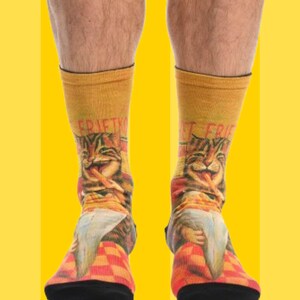 May include: A pair of yellow and orange socks with a graphic print of a cat eating fries. The socks have the text "Just Fries" on one sock and "Just Fries" on the other sock.