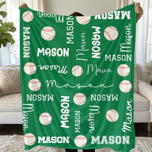 Op de afbeelding: Groene baseball-thema deken met de naam "Mason" in het wit, samen met honkballen. De deken toont de naam in verschillende lettertypen en oriëntaties, wat een gepersonaliseerd ontwerp creëert.