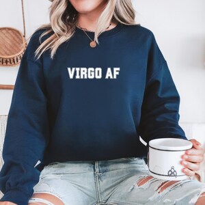 May include: A navy blue sweatshirt with the text "VIRGO AF" printed in white on the front.
