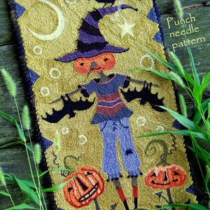 Puede incluir: Patrón de aguja de punzón con una bruja con cabeza de calabaza, murciélagos y una luna creciente. La bruja lleva un sombrero morado, una camisa a rayas, pantalones vaqueros azules y botas rojas. El patrón está sobre un fondo amarillo con hierba verde y un patrón a cuadros en la parte inferior. El texto "Punch needle pattern" está en la esquina superior derecha.