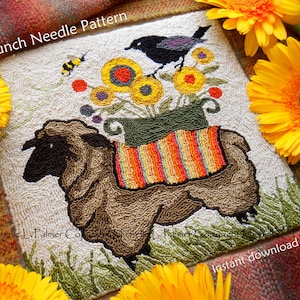 Op de afbeelding: Prikpatroon met een bruin schaap dat een pot met kleurrijke bloemen draagt ​​waarop een zwarte vogel zit. De pot heeft oranje en gele strepen. Het patroon is omgeven door gele bloemen.