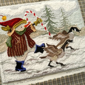 May include: A needlepoint wall hanging depicting a snowman wearing a red hat and blue boots, holding a candy cane. The snowman is surrounded by snow and three geese flying in the background. The text "Lurch of the Christmas Geese" is written at the bottom of the image.