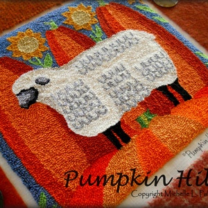 Puede incluir: Una oveja blanca se encuentra sobre un lecho de calabazas naranjas con hojas verdes y girasoles amarillos. El texto "Pumpkin Hill" y "Copyright Michelle L. Palmer" está impreso debajo de la oveja.