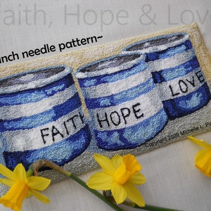 May include: Punch needle pattern for a craft project featuring three blue and white striped cans with the words "Faith", "Hope", and "Love" on them. The cans are surrounded by yellow daffodils.