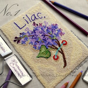 以下が含まれることがあります： クリーム色の背景に、「Lilac」と「Botanical Collection #1 of 20」のテキストが書かれた、ライラックの花の針仕事刺繍のクローズアップ。