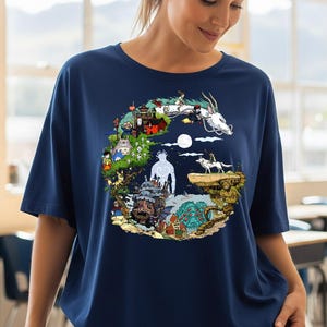 Pu&ograve; includere: T-shirt blu navy con una grafica circolare colorata raffigurante personaggi animati e un drago bianco. Il design include varie scene e figure, creando un design dettagliato e stravagante. La maglietta ha maniche corte e una vestibilit&agrave; ampia.