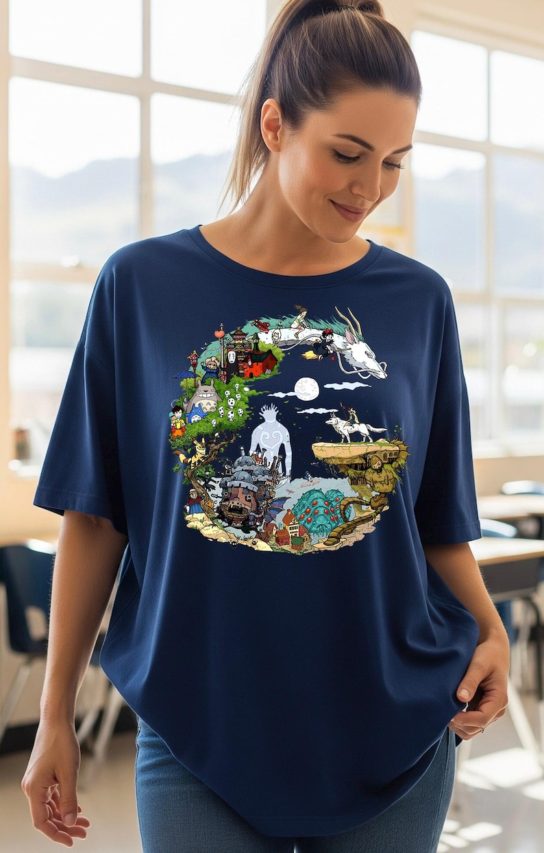 Pu&ograve; includere: T-shirt blu navy con una grafica circolare colorata raffigurante personaggi animati e un drago bianco. Il design include varie scene e figure, creando un design dettagliato e stravagante. La maglietta ha maniche corte e una vestibilit&agrave; ampia.