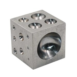 May include: A silver metal forming block with various sized concave depressions and holes. The cube-shaped tool is designed for shaping metal and jewelry making. The block has a brushed metal finish and is shown against a white background.