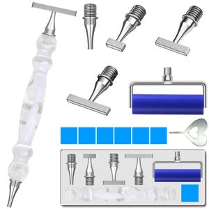 Puede incluir: Un conjunto de herramientas para pintura de diamantes, que incluye un bolígrafo transparente facetado con detalles plateados, varias puntas aplicadoras, un rodillo azul y una herramienta en forma de corazón. También se incluyen almohadillas adhesivas cuadradas azules.