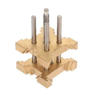 May include: A brass-coloured metal jig featuring four vertical silver rods and a central threaded rod. The jig has a layered design with interlocking sections, a precision tool for woodworking or metalworking.
