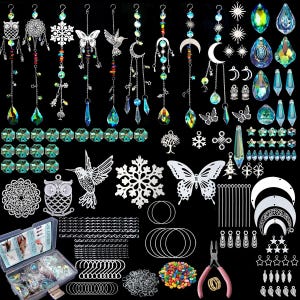 May include: A collection of suncatcher supplies and components, including hanging crystals, metal charms, chains, and tools. The assortment features various shapes like butterflies, moons, stars, and snowflakes, with a mix of clear and colorful beads and crystals.
