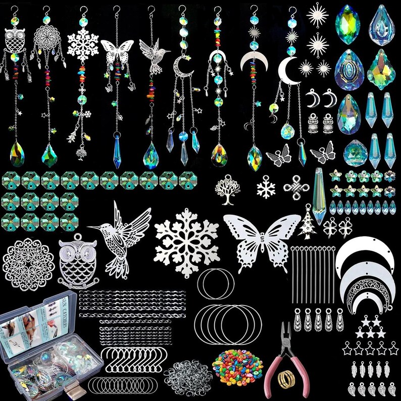 May include: A collection of suncatcher supplies and components, including hanging crystals, metal charms, chains, and tools. The assortment features various shapes like butterflies, moons, stars, and snowflakes, with a mix of clear and colorful beads and crystals.