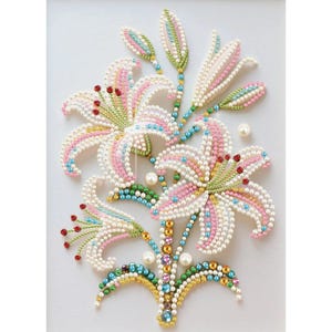 May include: A detailed floral design featuring lilies, crafted with white, pink, and blue beads. The artwork showcases a bouquet of lilies with pearl-like beads, accented with red and green details, creating a vibrant and textured appearance.