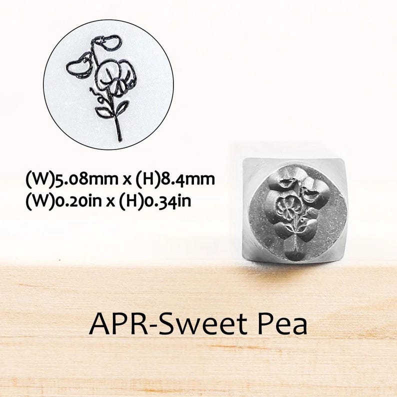 Pode incluir: Um carimbo de metal com um desenho de flor de ervilha-de-cheiro. O carimbo mede 5,08 mm de largura e 8,4 mm de altura. O texto "APR-Sweet Pea" est&aacute; abaixo. &Eacute; mostrada uma imagem de perto da flor.