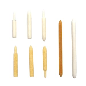 May include: An assortment of wooden dowels and pegs in various sizes and colors. The collection includes light beige, tan, and a single dark brown dowel. Some pegs have a rounded top, while others have a pointed tip. The items are arranged against a white background.