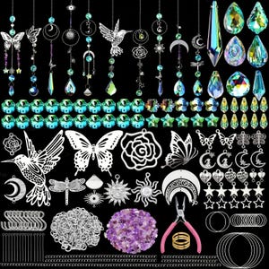 May include: A collection of colourful crystal suncatchers, butterflies, and other decorative elements. The suncatchers are made of glass and feature a variety of shapes and colours, including blue, green, purple, and red. The butterflies are made of metal and have a silver finish. The other decorative elements include a rose, a bird, and a heart. The suncatchers are strung on a string and can be hung from a window or ceiling.