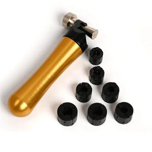 May include: A gold-colored handle tool with a black head and a silver-toned adjustment knob, accompanied by six small, cylindrical black collets with vertical slits arranged in a cluster next to the main tool body.