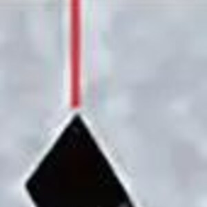 May include: A red laser beam pointing down at a 75 degree angle towards a black object.