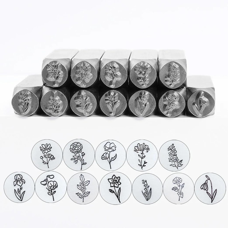 Pode incluir: Um conjunto de carimbos de metal com v&aacute;rios desenhos florais. Cada carimbo tem uma pega quadrada e uma cabe&ccedil;a circular com um desenho floral detalhado. A imagem tamb&eacute;m mostra as impress&otilde;es carimbadas de cada flor.