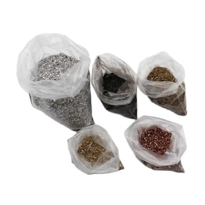 May include: Five clear plastic bags filled with various decorative metallic flakes. The collection includes silver, black, bronze, gold, and copper-colored fragments, each contained in its own individual transparent pouch for easy identification.