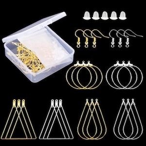 Peut inclure: Un assortiment de fournitures de fabrication de bijoux, comprenant des crochets d'oreilles, des cerceaux et des cadres triangulaires et en forme de goutte d'eau de couleur or et argent. Un récipient en plastique transparent contient des apprêts et des fermoirs d'oreilles supplémentaires.