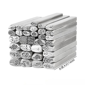 Op de afbeelding: Een stapel zilveren metalen stempels met diverse wolken- en wervelontwerpen. De rechthoekige stempels zijn ongeveer 7,4 cm lang. De ontwerpen omvatten gestileerde wolken en andere decoratieve patronen.
