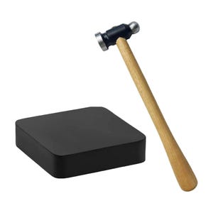 May include: A black square bench block and a ball-peen hammer. The hammer has a wooden handle and a black head with a flat face and a rounded ball. The bench block is for metalworking.
