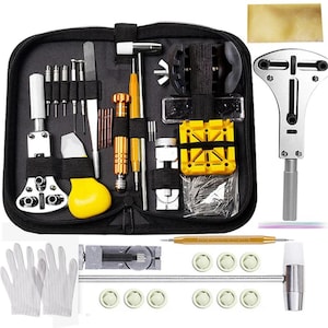 May include: A black zippered case containing a watch repair kit. The kit includes various tools such as screwdrivers, a hammer, a case opener, and a watch holder. Also included are white gloves and watch parts.